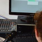 Software Update - Unrecognizable sound engineer installing software on desktop computer at home