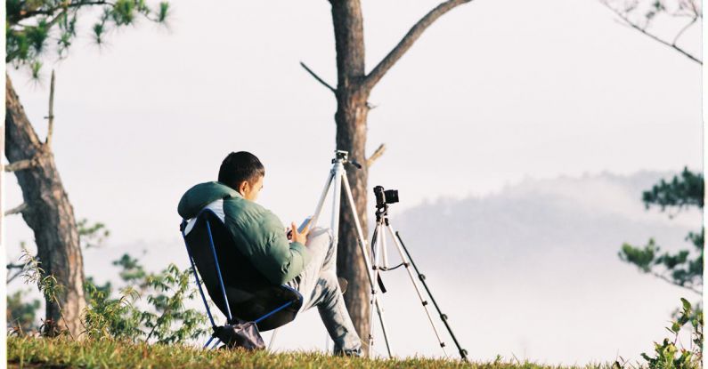 Smartphone Tripods - Man Sitting on a Chair on a Hill with Tripods and Cameras