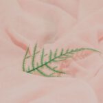 E-textiles - Close-up of a Fern Leaf Lying on Light Pink Fabric